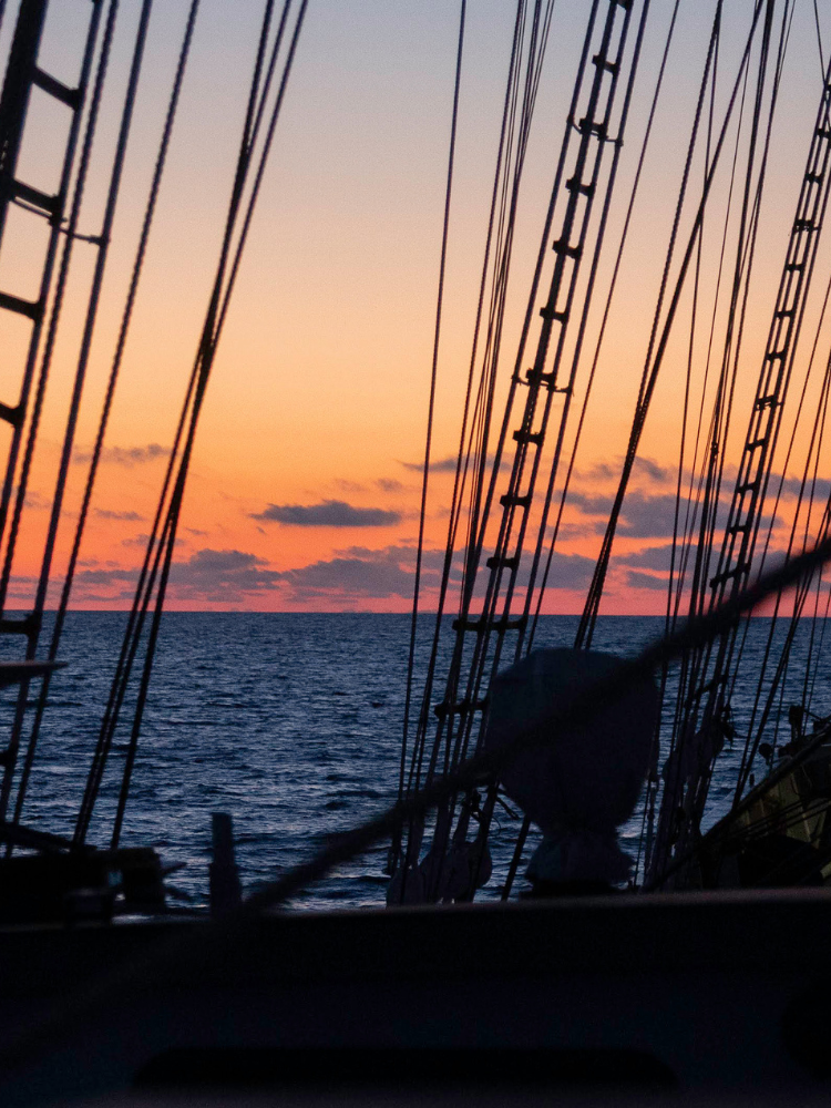 Sailboat with sunset sky and ocean in the background